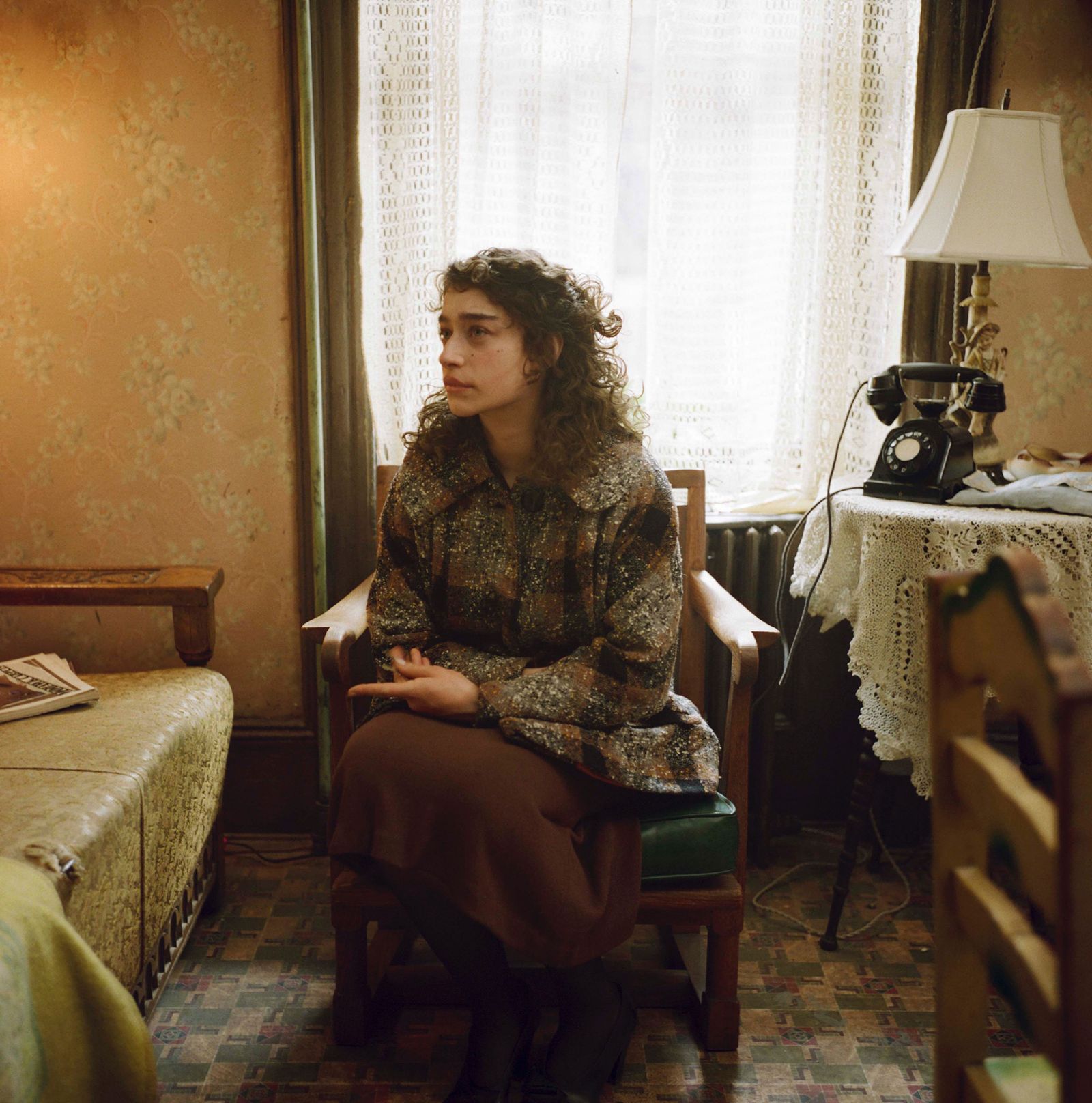 Image may contain Adult Person Chair Furniture Sitting Curly Hair Hair Clothing Footwear High Heel Shoe and Face